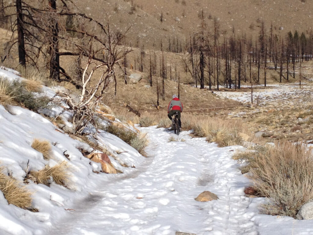 Navigating a snowfield while mountain biking the Pipeline trail, near Aspendell. 