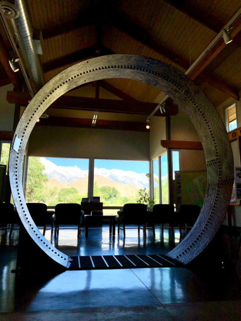 Panoramic view of the Sierra Nevada and Mt. Whitney from the Interagency Visitor Center near Lone Pine. A section of the Los Angles Aquaduct pipe on display. 